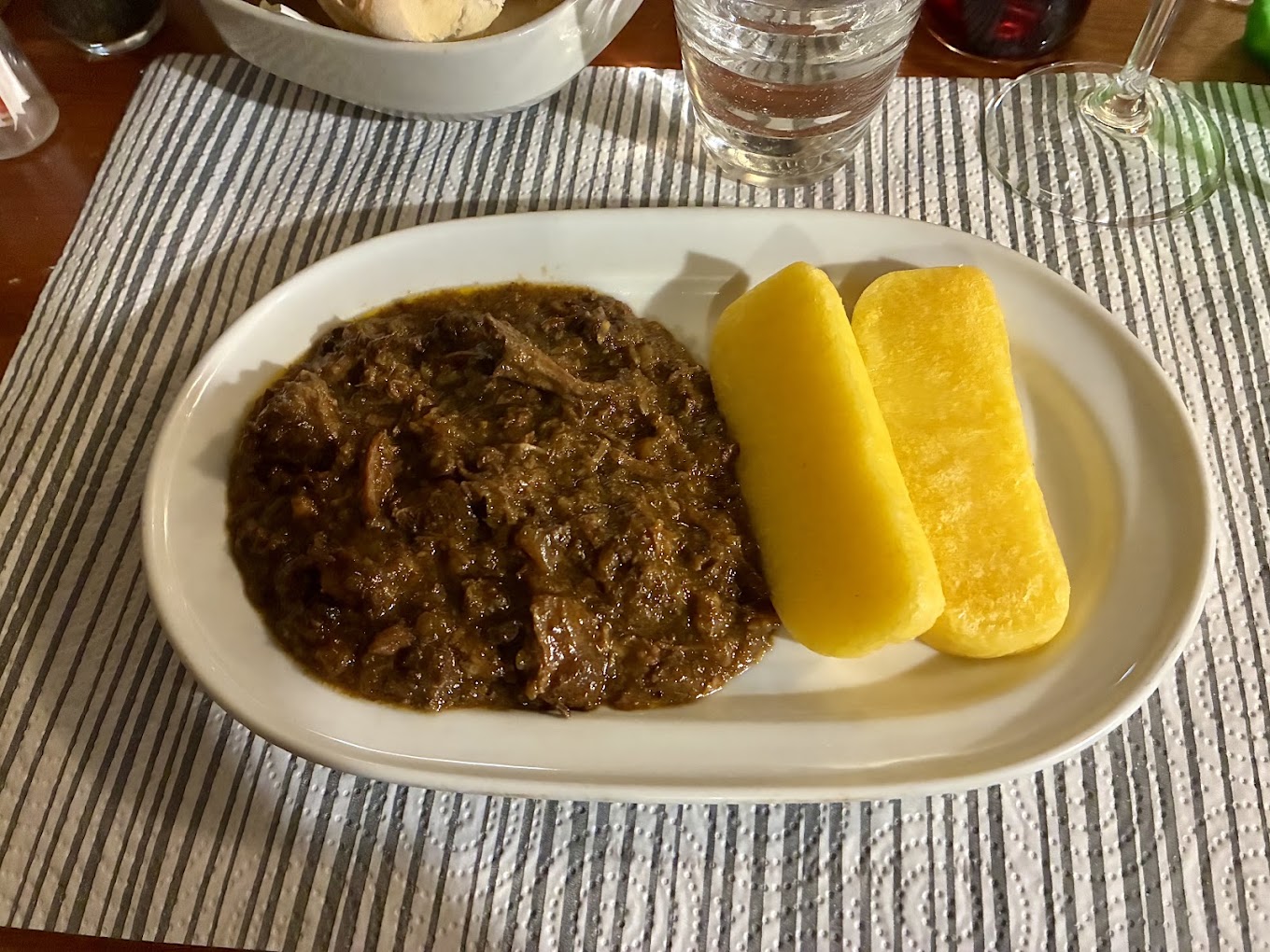 Carne in umido servita con due fette di polenta